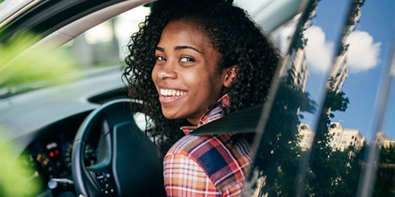 young girl looking out her car window 