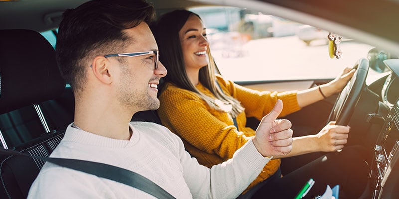 Woman taking a defensive driving course and getting the thumbs up from her instructor