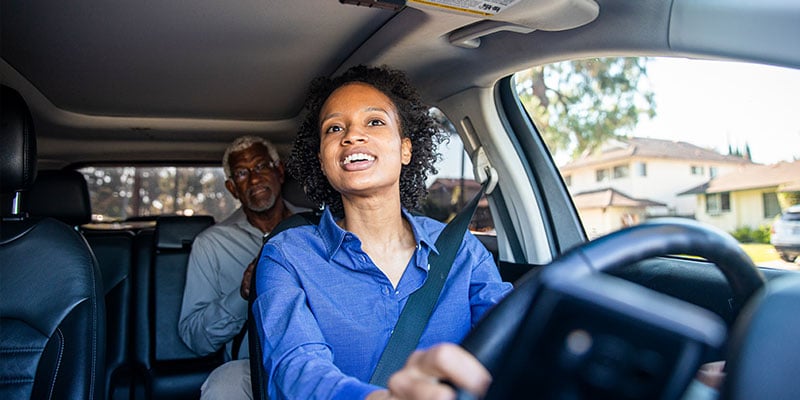 Woman driving older passenger in the car 